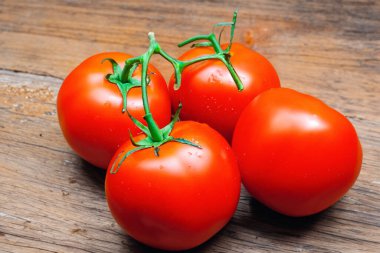 Tahta masadaki olgun kırmızı domatesler.