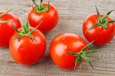 Tahta bir masada taze kırmızı domatesler.