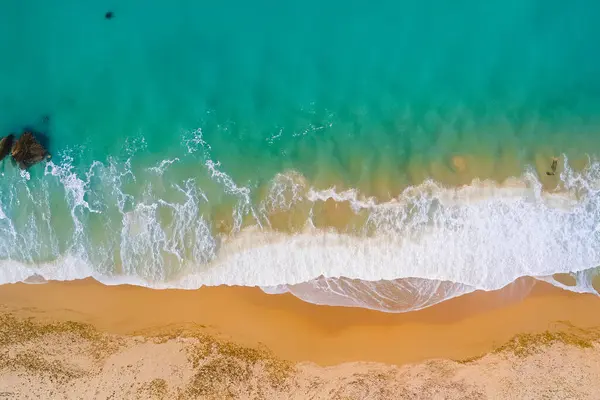Dalgalar ve deniz manzaralı bir plaj. üstten aşağı görünüm.
