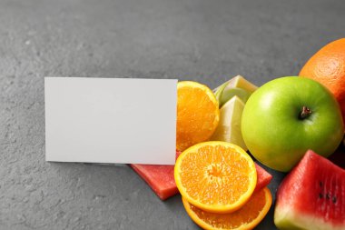 Gri bir zemin üzerinde taze sulu meyveler ve fotokopi alanı