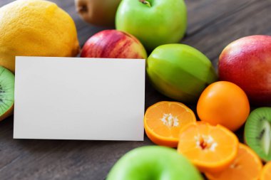 Taze meyve ve ahşap arka planı olan not kağıdı.