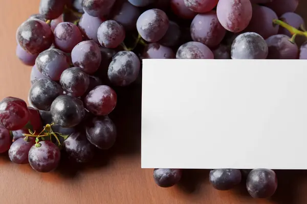 stock image blank paper and white grapes on a wooden background.