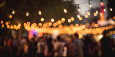 Festival partisi açık havada, insanların geçmişi bulanık, tatilde ışıklar süslemesi