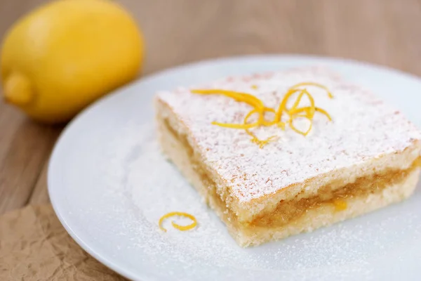 Close-up of a lemon pie on a white plate, shortcrust pastry.