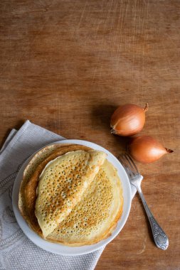 Ahşap arka planda soğanlı krep (Russian Blini), üst manzara, fotokopi alanı. Kahvaltıda ev yapımı taze krep. Dikey