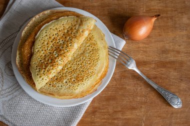 Ahşap arka planda soğanlı krep (Russian Blini), en iyi manzara. Kahvaltıda ev yapımı taze krep.