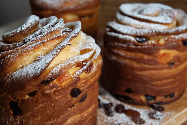 Mutlu Paskalyalar. Geleneksel Paskalya pastaları, ev yapımı kuru üzümlü kraffinler, şekerli meyveler. Seçici odaklanma. Ev yapımı Cruffin 'e yakın çekim. Ahşap arkaplan.