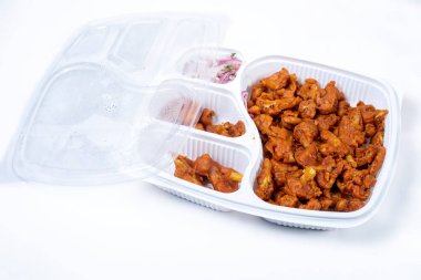 Hindistan 'da beyaz arka planda izole edilmiş plastik kutuda kızarmış Gobi Mançuryalı. Üst görünüm.