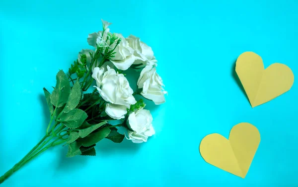 情人节 蓝色背景下的一束白玫瑰和黄色的心 — 图库照片