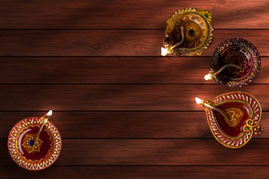Mutlu Diwali - Clay Diya lambaları Dipavali kutlamaları sırasında ahşap arka planda yakıldı. Üst görünüm
