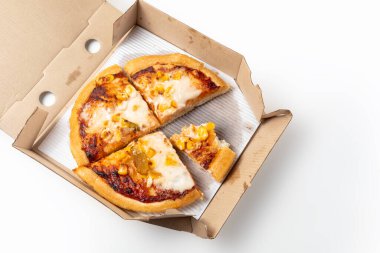 Beyaz arka planda, karton bir kutuda mısır pizzası..