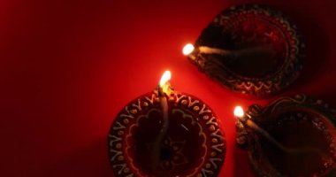 Kırmızı arka planda gaz lambası yanıyor. Diwali kutlaması, ışık festivali.