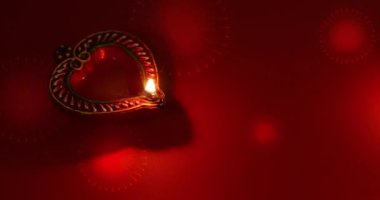 Kırmızı arka planda havai fişeklerle birlikte gaz lambası yanıyor. Diwali kutlaması, Deepam festivali, Karthigai Deepam festivali.