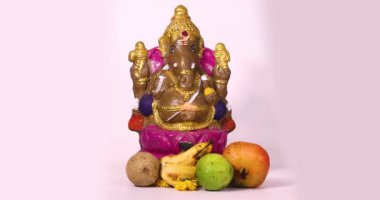 Ganesha Chaturthi festivali, Ganesha heykelinin Hint tanrısı Ganesha heykeli ve beyaz arka planda meyvelerle kutlanır..