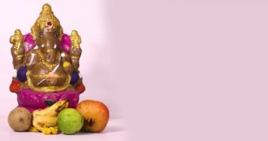 Ganesha Chaturthi festivali, Ganesha heykelinin Hint tanrısı Ganesha heykeli ve beyaz arka planda meyvelerle kutlanır..
