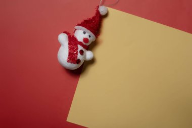 Noel konsepti. Metin için kopyalama alanı olan sarı ve kırmızı arkaplan üzerindeki kardan adam