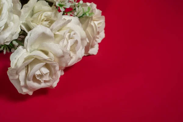 Bouquet of white roses on a red background with copy space for your text. Top view.