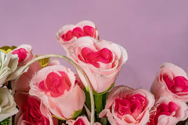 Bouquet of beautiful pink roses on a pink background.
