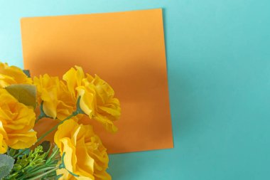 Mavi arka planda turuncu kağıtlı sarı güller..