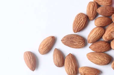 Beyaz arkaplanda bulunan ve kopyalama alanı olan bademlerin üst görünümü