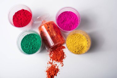 Beyaz arka planda izole edilmiş plastik kaplarda renkli holi tozu. Üst görünüm