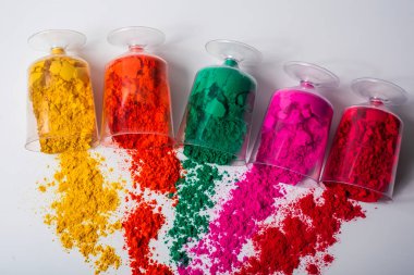 Beyaz arka planda plastik bir kapta renkli holi tozu. Üst görünüm