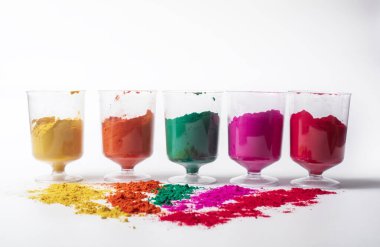 Beyaz arka planda cam kasede renkli holi tozu. Holi, Hint renk festivali.