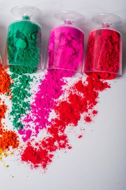 Beyaz arka planda plastik kaplarda renkli holi tozu. en üstteki görünüm