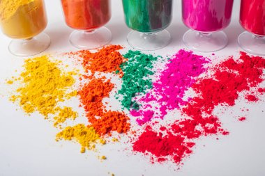 Beyaz arka planda izole edilmiş camdaki renkli holi tozu. Holi festivali konsepti. Seçici odak.