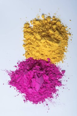 Beyaz arka planda izole edilmiş renkli holi tozu yığını. Dikey çekim