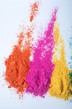Beyaz arkaplanda izole edilmiş çok renkli holi tozunun üst görüntüsü. Seçici odak.