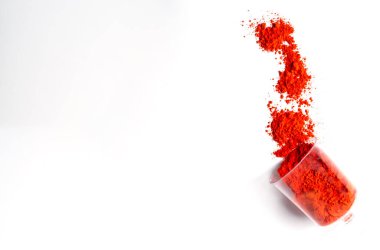 Beyaz arkaplanda izole edilmiş bardaktaki renkli kırmızı holi tozu metin için kopyalama alanı