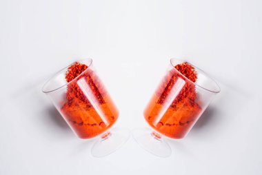 Beyaz arka planda iki bardak kırmızı holi tozu..