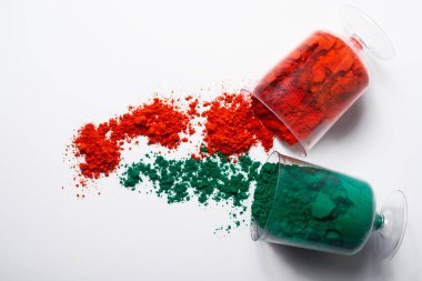 Beyaz arka planda izole edilmiş camdaki renkli holi tozu. Holi geleneksel bir Hint festivali.