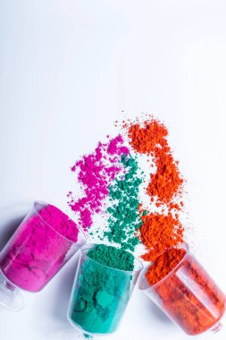 Beyaz arka planda plastik bir kapta renkli holi tozu. Üst görünüm