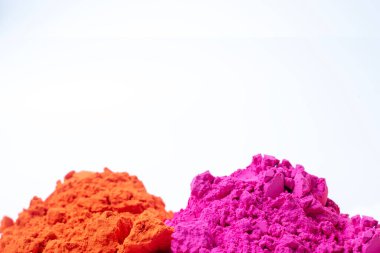 Beyaz arka planda izole edilmiş renkli holi tozu yığını. Yakın çekim.