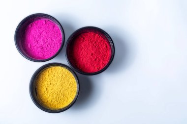 Beyaz arka planda izole edilmiş bir kasede renkli holi tozu. Holi, Hindistan 'ın renk festivali.