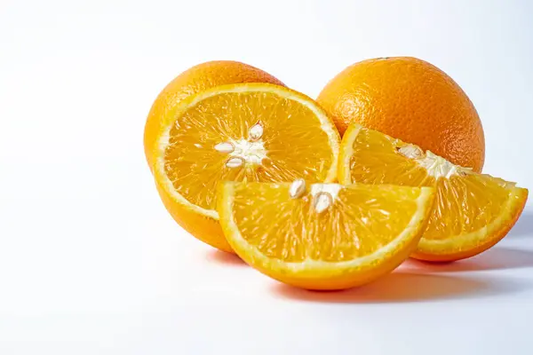 橙子在白色的背景上被分离出来 切割成两半 并有切割路径 图库照片