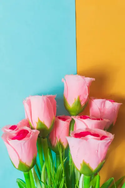 Bouquet Mawar Merah Muda Pada Latar Belakang Biru Dan Kuning Stok Foto