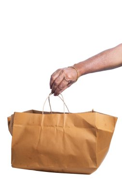 El ele tutuşan kahverengi kağıt poşet beyaz arka planda, kırpma yolu ile izole edilmiş. Yakın çekim.