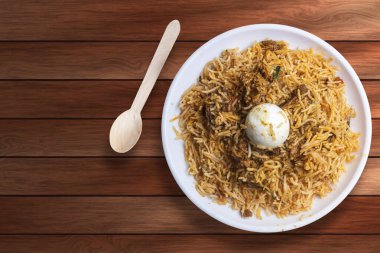 Hint yemeği lezzetli biryani beyaz tabak üzerinde ahşap masa. Üst görünüm