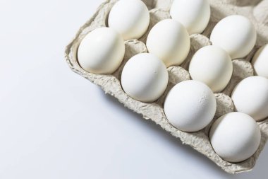 Beyaz arka planda kutuda beyaz yumurtalar. Üst görünüm.