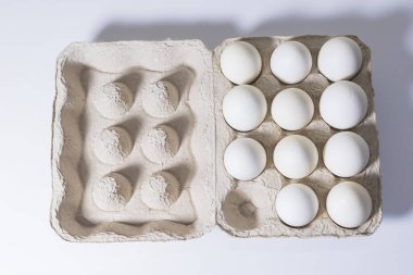 Beyaz arka planda karton kutuda tavuk beyazı yumurtalar. Üst görünüm