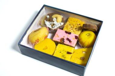 Geleneksel çeşitli Hint şekerleri beyaz yüzeydeki karton kutuda sütten yapılır. Üst görünüm