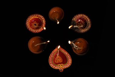 Mutlu Diwali - Diwali petrol lambalarının üst görünümü siyah arka planda yanarken.