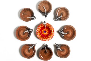 Traditional clay oil lamps are arranged in a circle during Diwali festival. Top view clipart