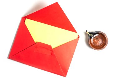 Diwali festivali için beyaz zemin üzerinde el yapımı kil diya ile boş sarı tebrik kartı olan kırmızı zarf. Davetiyeler ya da Kutlamalar için ideal.