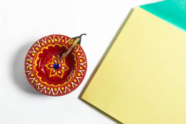 stock image Happy Diwali celebration greeting card and clay diya lamp on white background. Top view