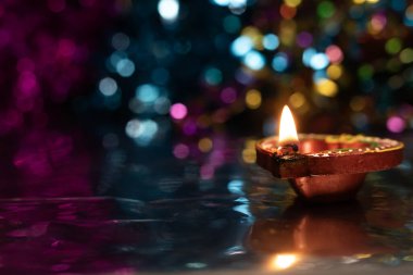 Koyu arkaplanda bokeh etkisi olan güzel ışık yansıması ile parlayan Diwali diyas. Seçici odak.
