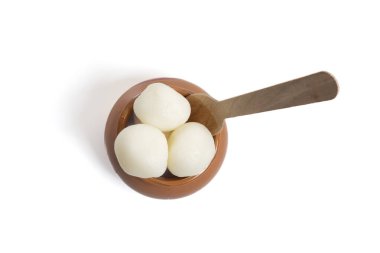 Top view of traditional Indian rasgulla served in a clay pot with a wooden spoon on white background. Perfect for indian festive occasion. clipart